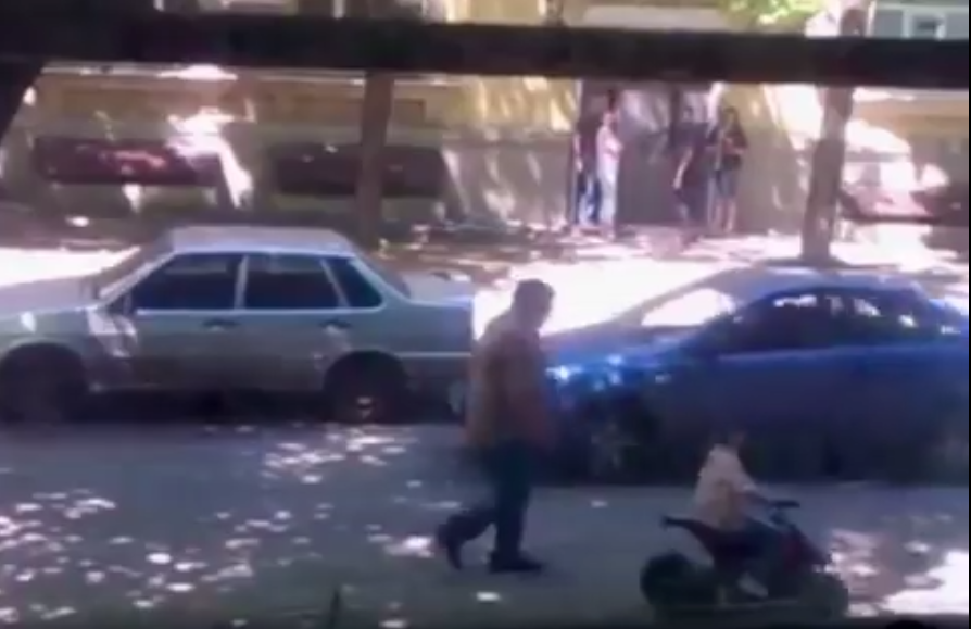 Видео, как по проезжей части улицы Чичибабина мужчина учит кататься маленького ребенка