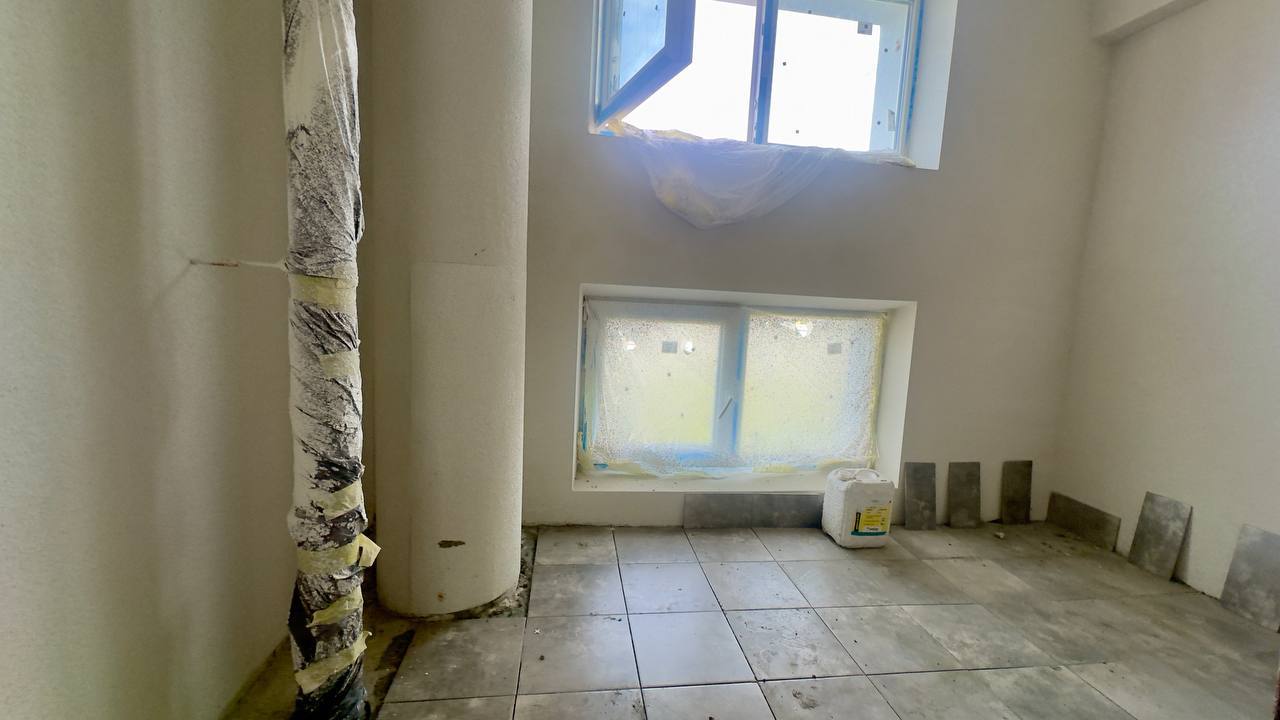 Від покрівлі до фасадів: у пошкодженій ворожими снарядами харківській багатоповерхівці тривають активні ремонтні роботи